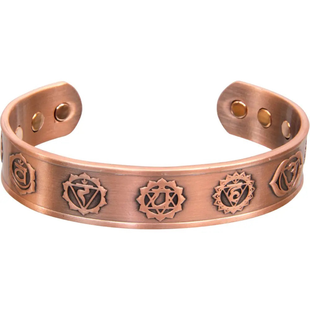 Copper bracelet with engraved symbols on a white background