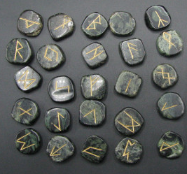 Set of stone runes with gold inscriptions on a dark background
