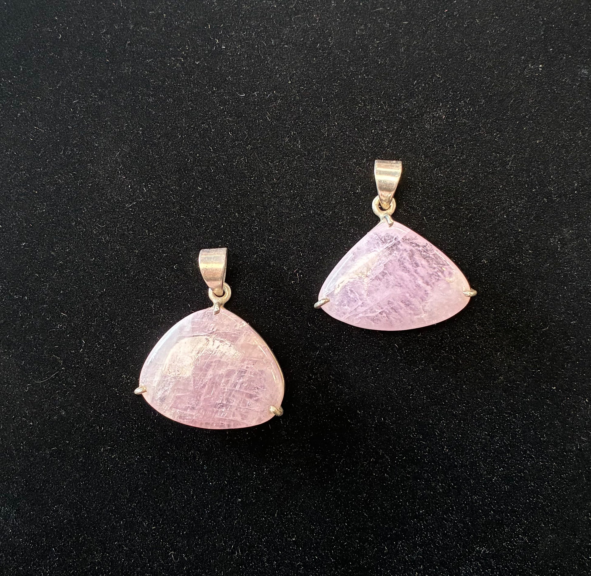 Two pink stone pendants on a black background