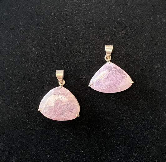 Two pink stone pendants on a black background