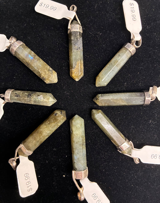 Green crystal pendants on a black background with price tags.