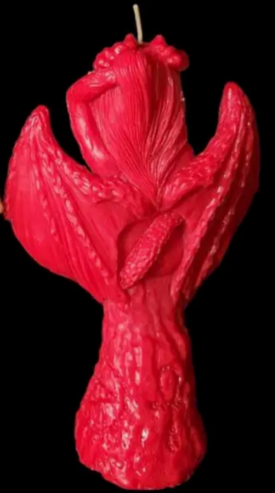 Red candle shaped like Lilith back on a black background
