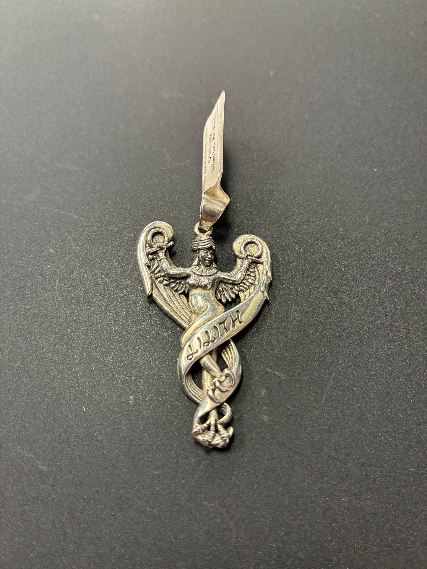 Silver pendant depicting Lilith with feathers and clawed feet.