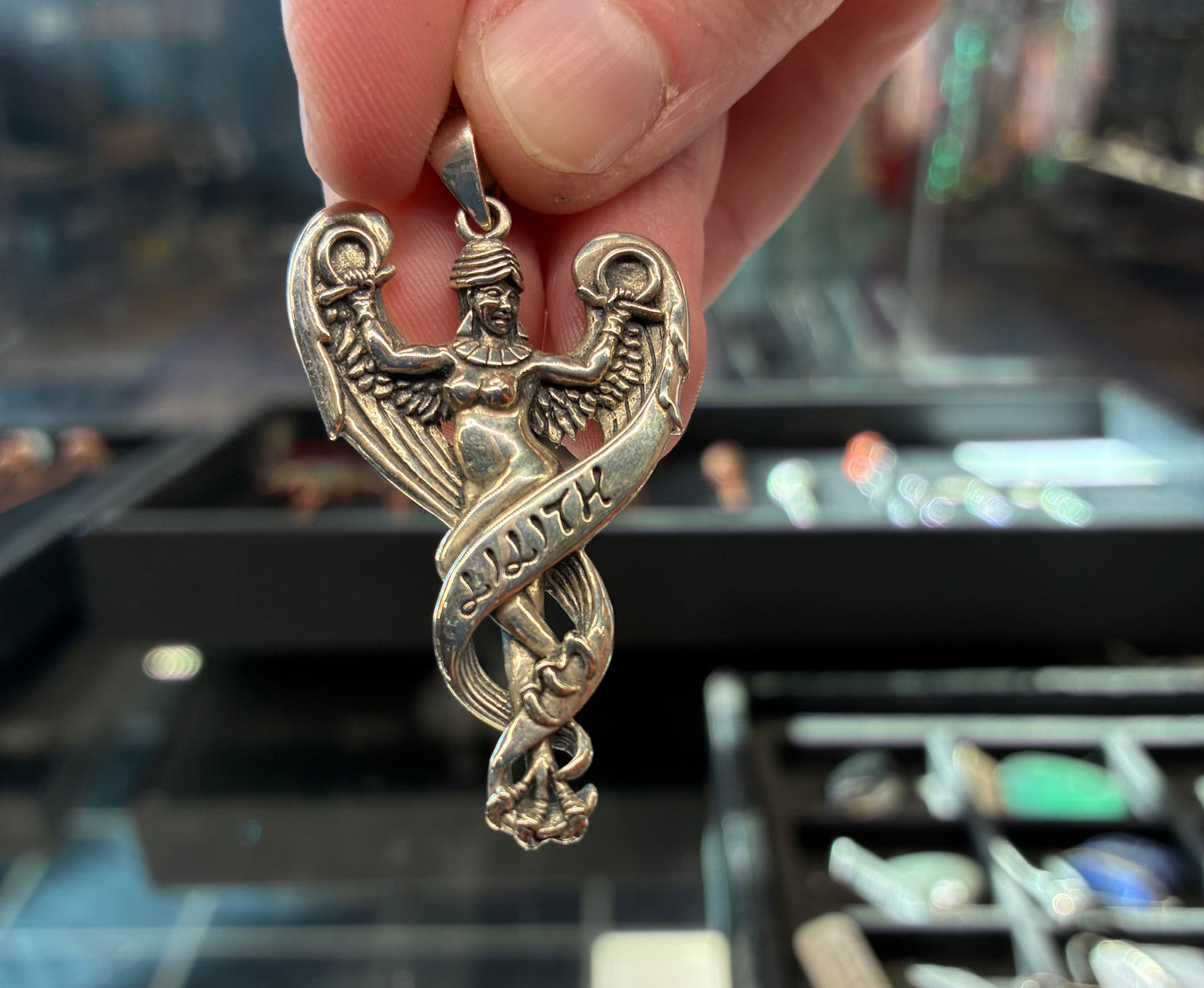 Silver pendant depicting Lilith with feathers and clawed feet.