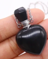 Black heart-shaped pendant with a chain on a white background