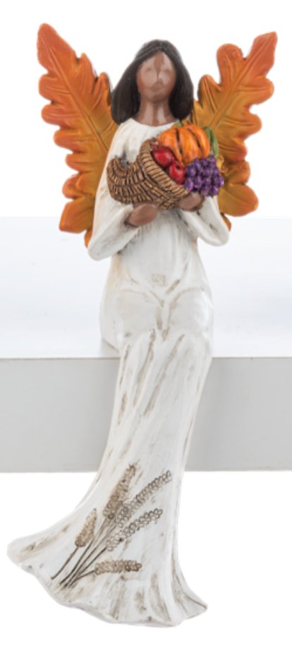 Decorative angel figurine holding a basket of fruits and vegetables with leafy wings on a white background