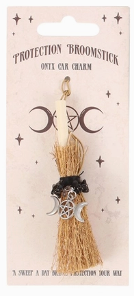 A small witch-style broom charm on a printed backing card. The charm includes a light wood handle, tan bristles, a black ribbon, and silver crescent moon and pentagram charms.