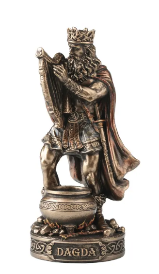 A bronze-finished decorative figurine of a crowned king with a beard and draped cape, standing on a cauldron-like base with the word 'DAGDA' on the front, isolated on a white background.