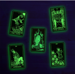 Five black tarot cards with glowing green illustrations and text, arranged on a dark purple background.