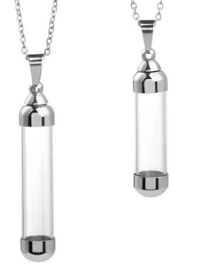 Two silver cylinder pendant necklaces with clear glass vial bodies and polished metal caps, shown on a plain white background.