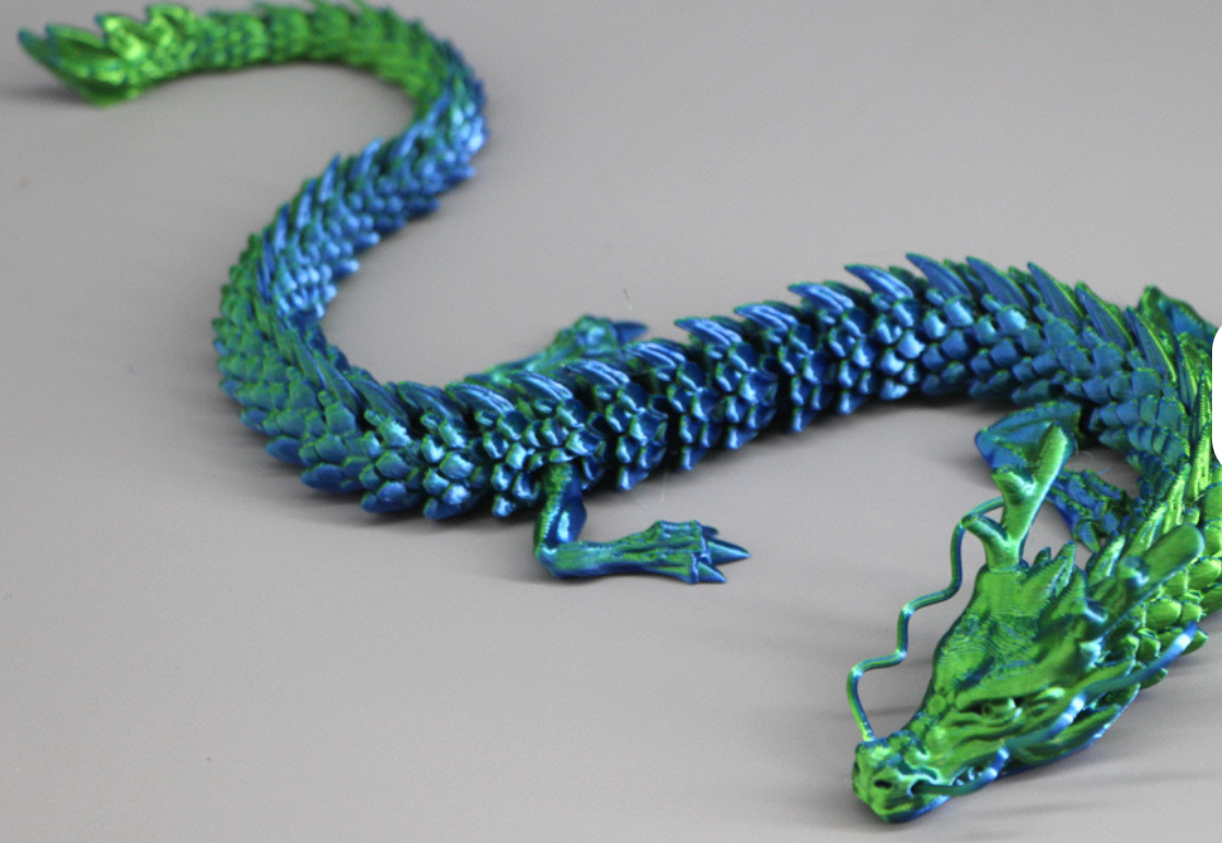 Metallic blue and green dragon sculpture on a gray background