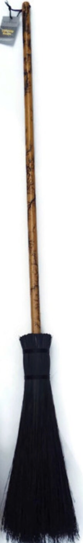 Traditional broom with black bristles and wooden handle on a white background