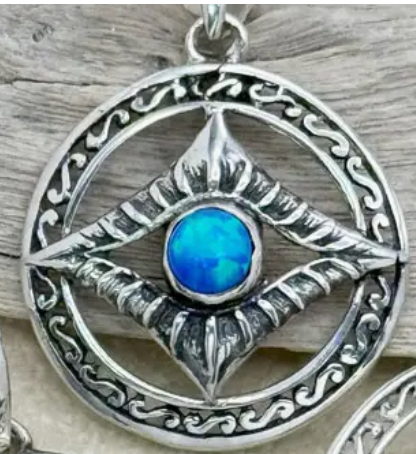Silver pendant with a blue stone on a wooden background