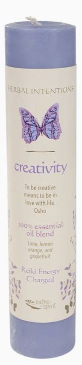 Candle with butterfly design and 'creativity' text on a white background