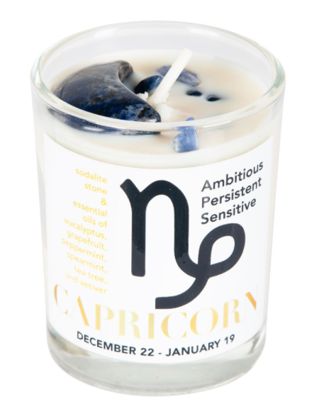 Candle in a glass jar with a Capricorn zodiac symbol and descriptive text on a white background