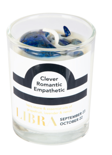 Candle in a glass jar with decorative stones and a label indicating 'Libra' on a white background