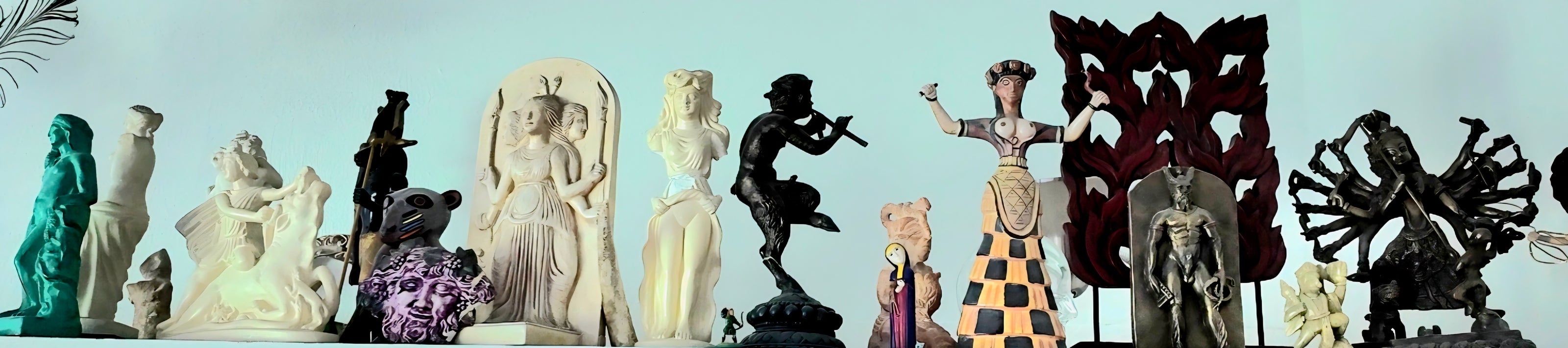 A collection of diverse ceramic figurines and decorative sculptures displayed side-by-side against a pale blue background.