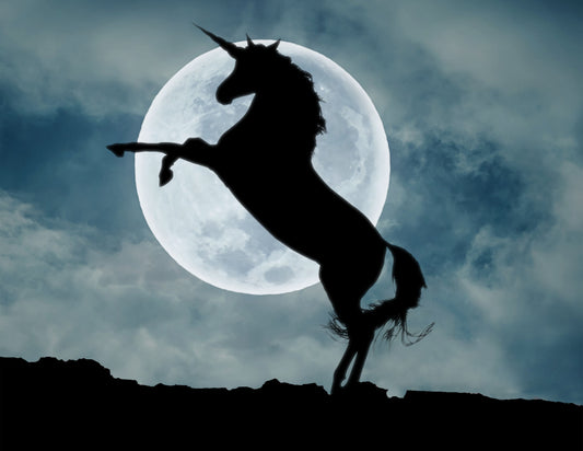 Silhouette of a unicorn leaping in front of a full moon with a dark, cloudy sky.