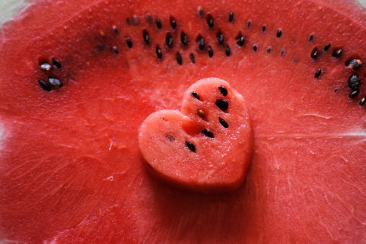 Heart-shaped piece of watermelon on a larger watermelon slice