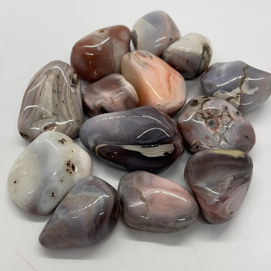 Pink, brown, and white tumbled stones with striations and quartz spots