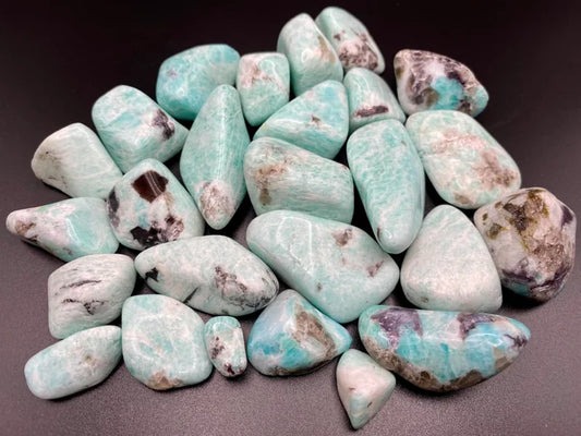 greenish blue stones with large spots of dark grey smoky quartz