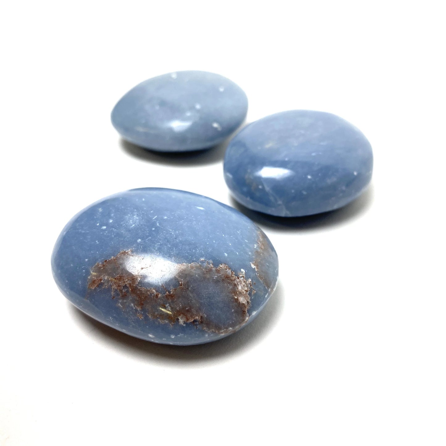 light blue angelite palm sized stones with light brown inclusions