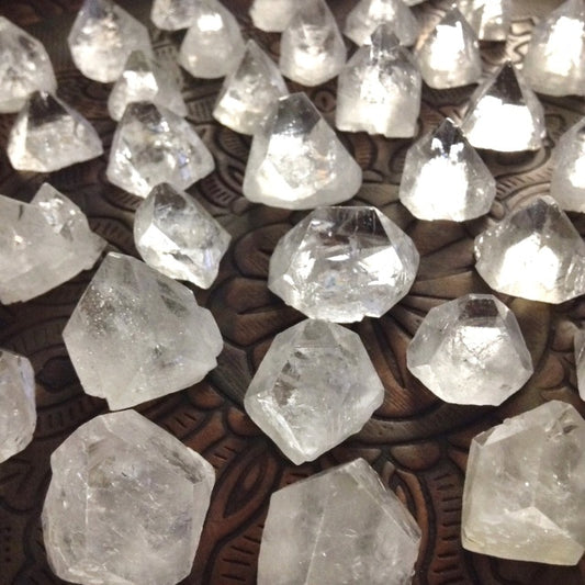 raw semi translucent stones, usually forming pyramids, in varying shades of clear, white, yellow, and green. Mostly very clear pieces