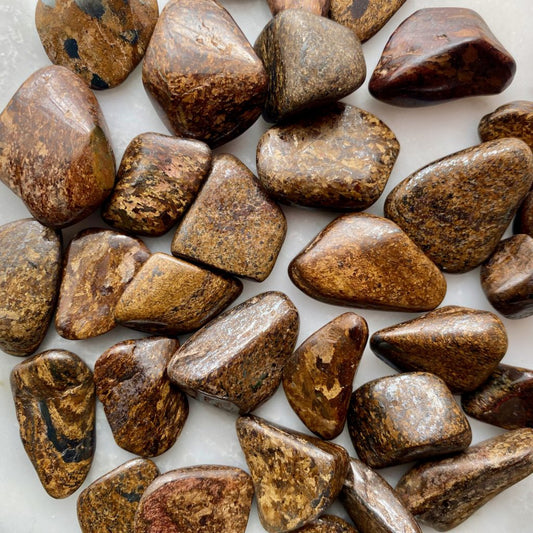 opaque, smooth, tumbled stones with yellow, light brown, and dark brown inclusions