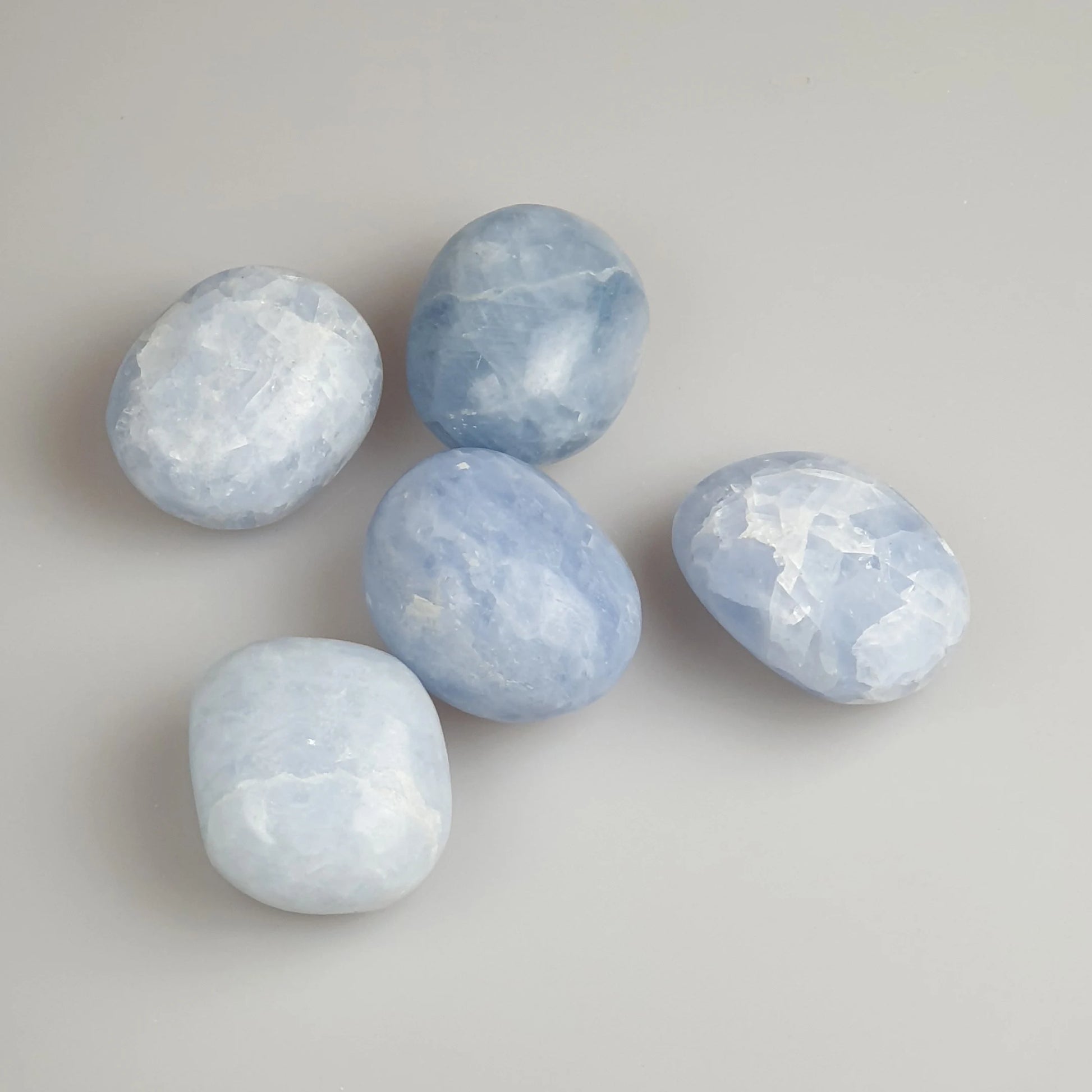 smooth, tumbled pieces of light blue stone with a waxy smooth surface