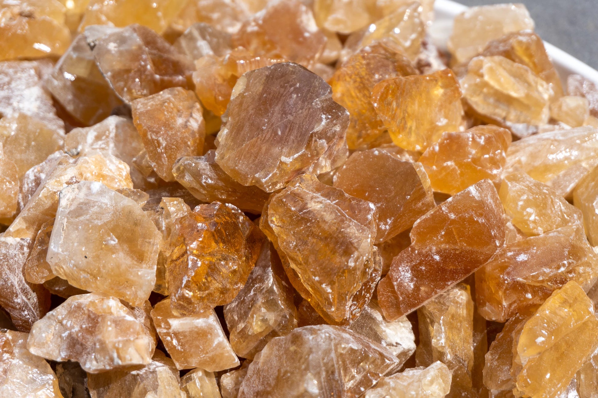 Raw, smooth, semi-translucent, light honey colored stones with a shiny waxy finish