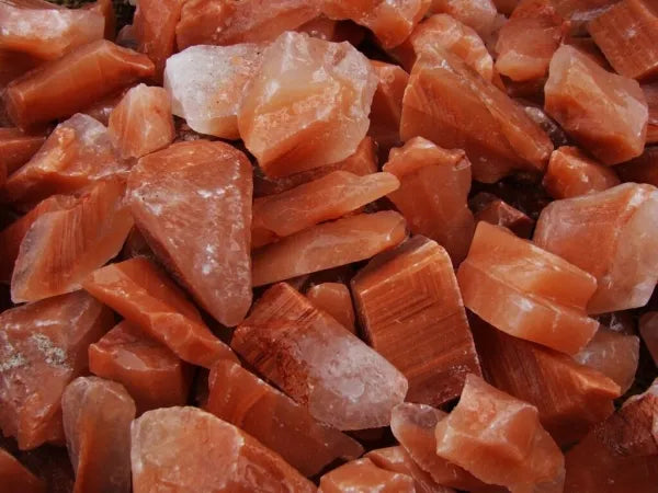 rough orange-red pieces of raw stones, with a smooth waxy finish