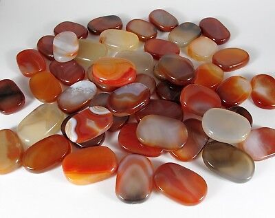 flat, oval, polished, semi-translucent. stones in shades of brown, red, orange, clear, and white