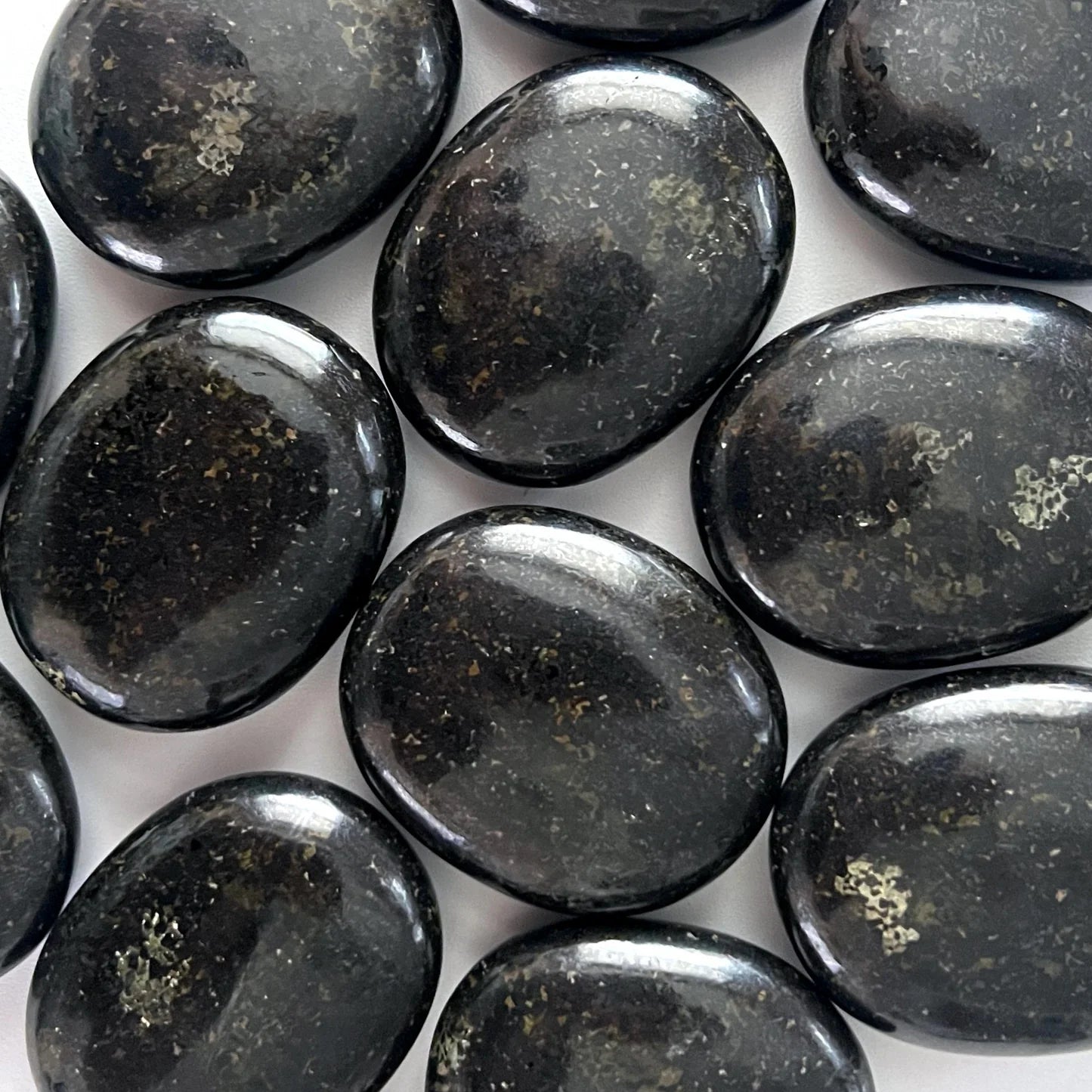 regular size palm stones black in color, with very reflective specks of silver, brown, and gold