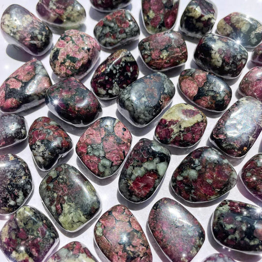 Reddish-pink, dark green, and black stones, tumbled with hexagonal pattern between the colors.