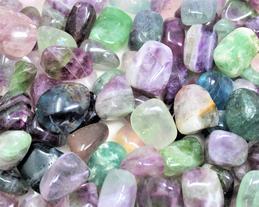 smooth polished tumbled stones in varying shades of green, turquoise, and purple