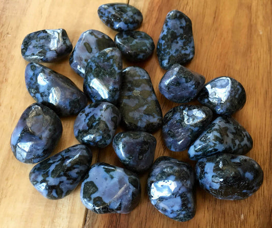 smooth tumbled black, grey, and purple speckled stones with varying colour shades.