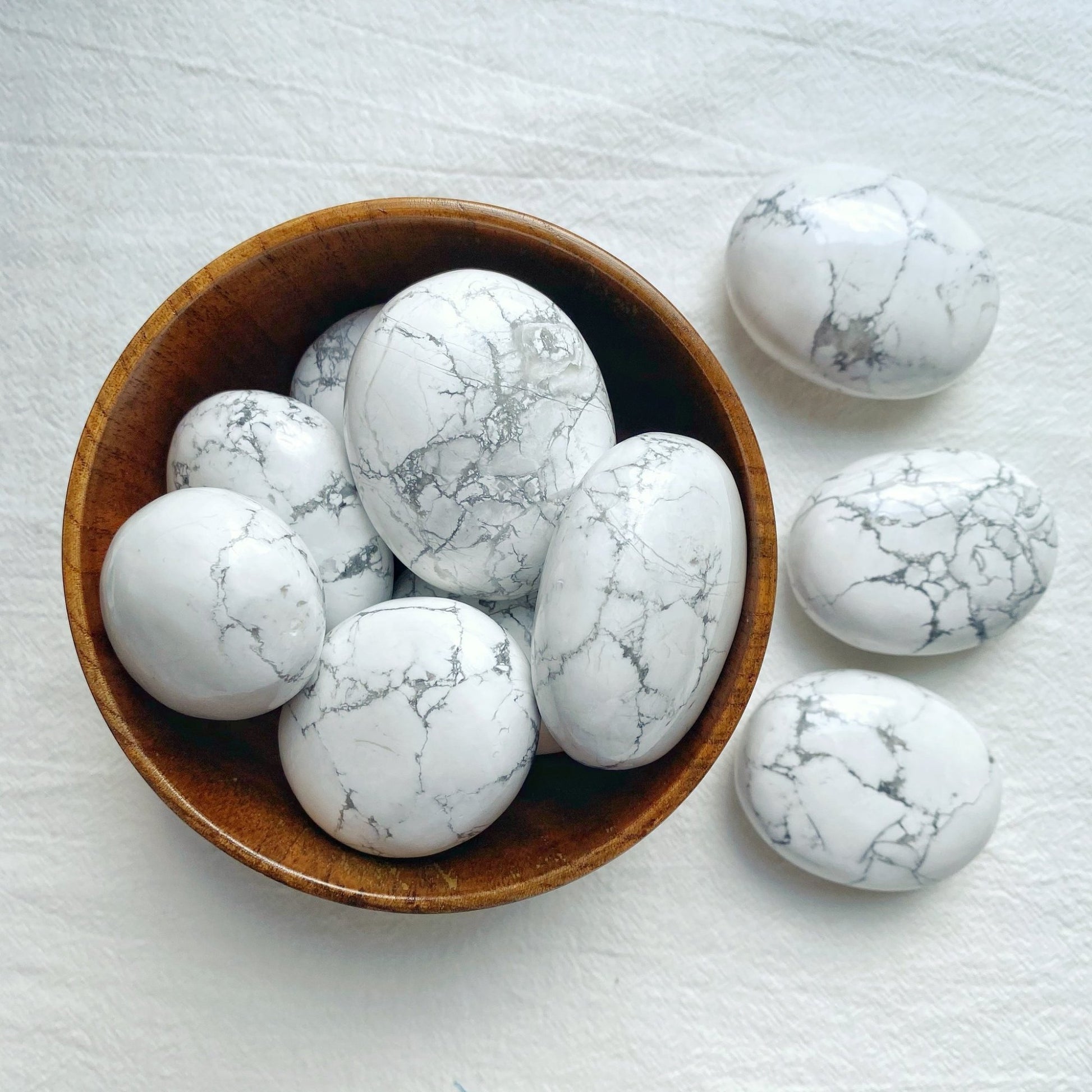 white smooth ovular palm sized stones with black and grey crackled pattern