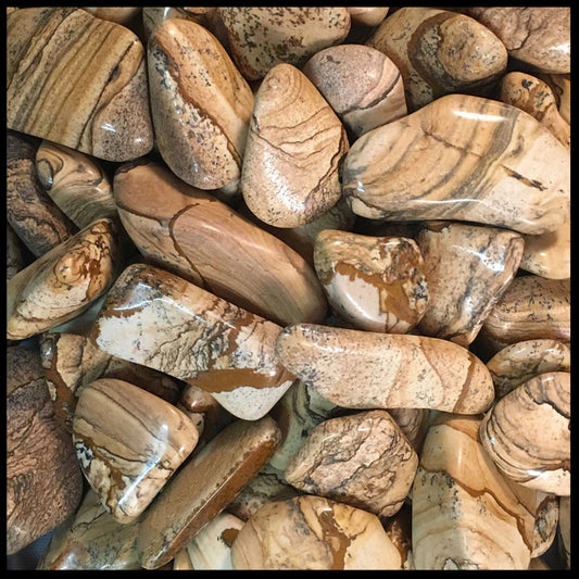 tumbled, smooth stones in a variety of sizes, in mostly shades of brown, white, and beige, with layered scenes and banded colours