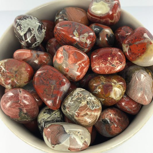 tumbled smooth stones, mostly red, but every piece has some amount of black or grey quartz running through it