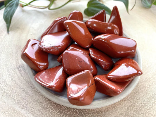 smooth, tumbled, red and reddish brown stones with black and cream inclusions.