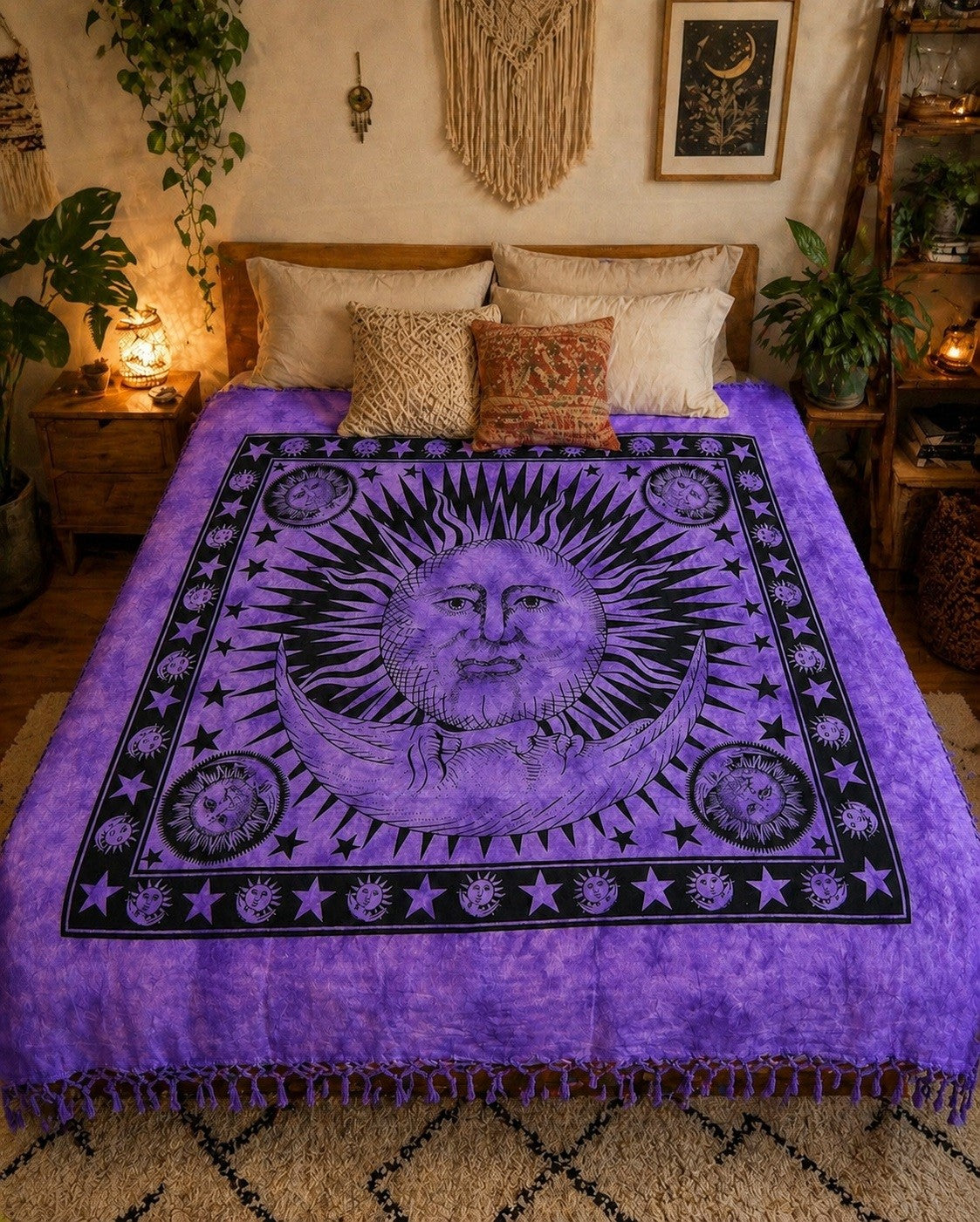 A purple and black tapestry-style bedding set with a celestial sun and moon design, styled on a bed in a warm, bohemian bedroom setting.