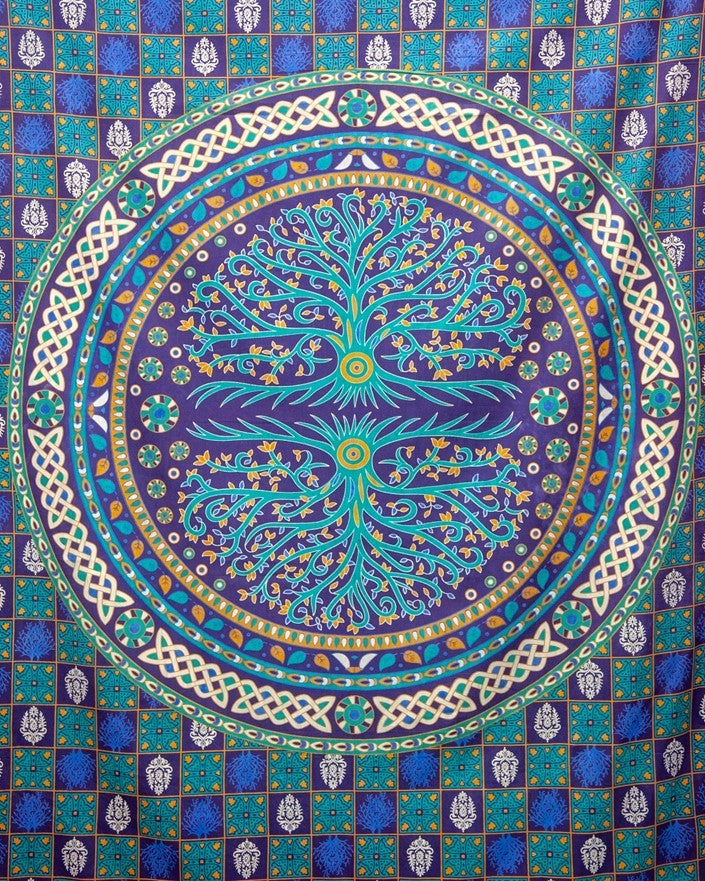 A square textile or tapestry featuring a large circular mandala design with a stylized tree of life in turquoise and teal on a deep purple center, surrounded by concentric decorative rings and a border of blue, green, and cream geometric motifs.