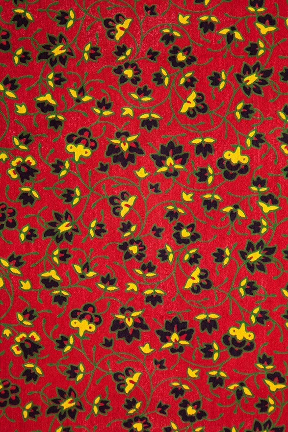 A close-up of tapestry  pattern featuring black and yellow flowers with green vines.