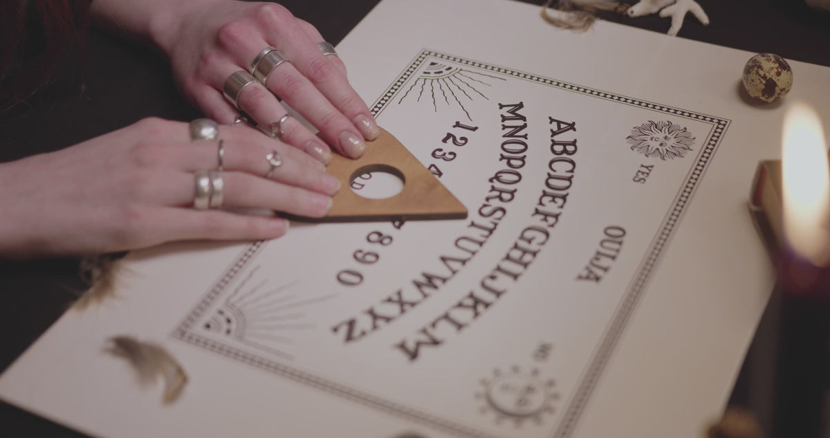 Load video: two hands on a white spirit board moving a planchet 