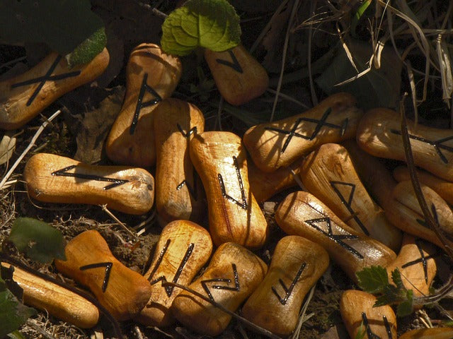 wooden runes on the ground with foliage