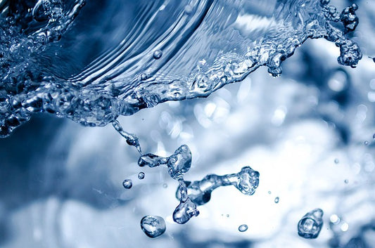 Close-up of water droplets and stream with a blurred background