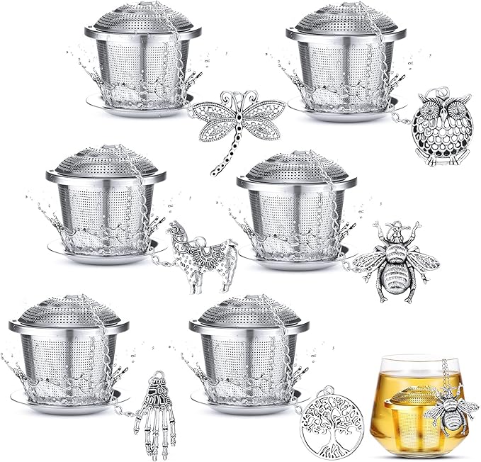 Set of silver metal tea infusers with decorative elements on a white background