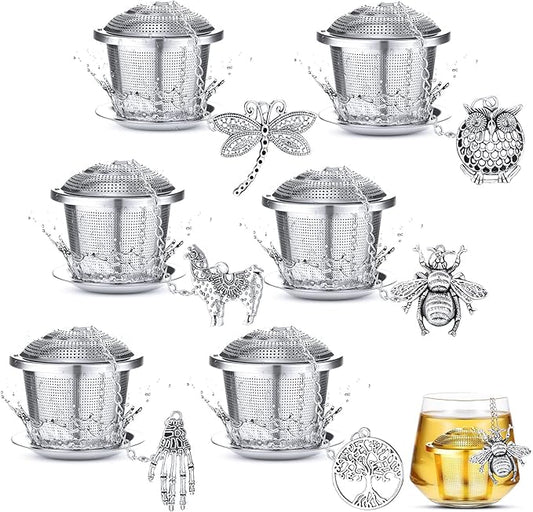 Set of silver metal tea infusers with decorative elements on a white background